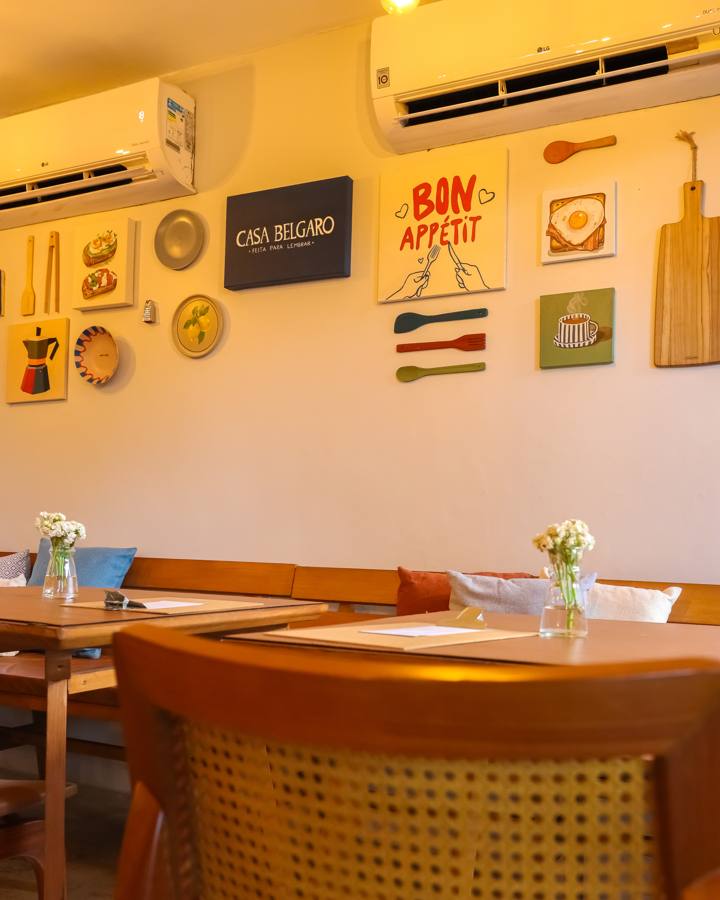 Detalhe da parede com quadros de café, ovos e o letreiro Casa Belgaro